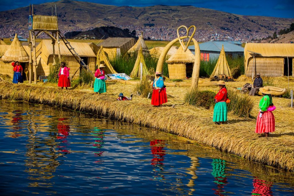 Local_women_waiting_for_visitors_at_the_edge_of_the_totora_reeds_island_in_the_Uros_Islands_Peru